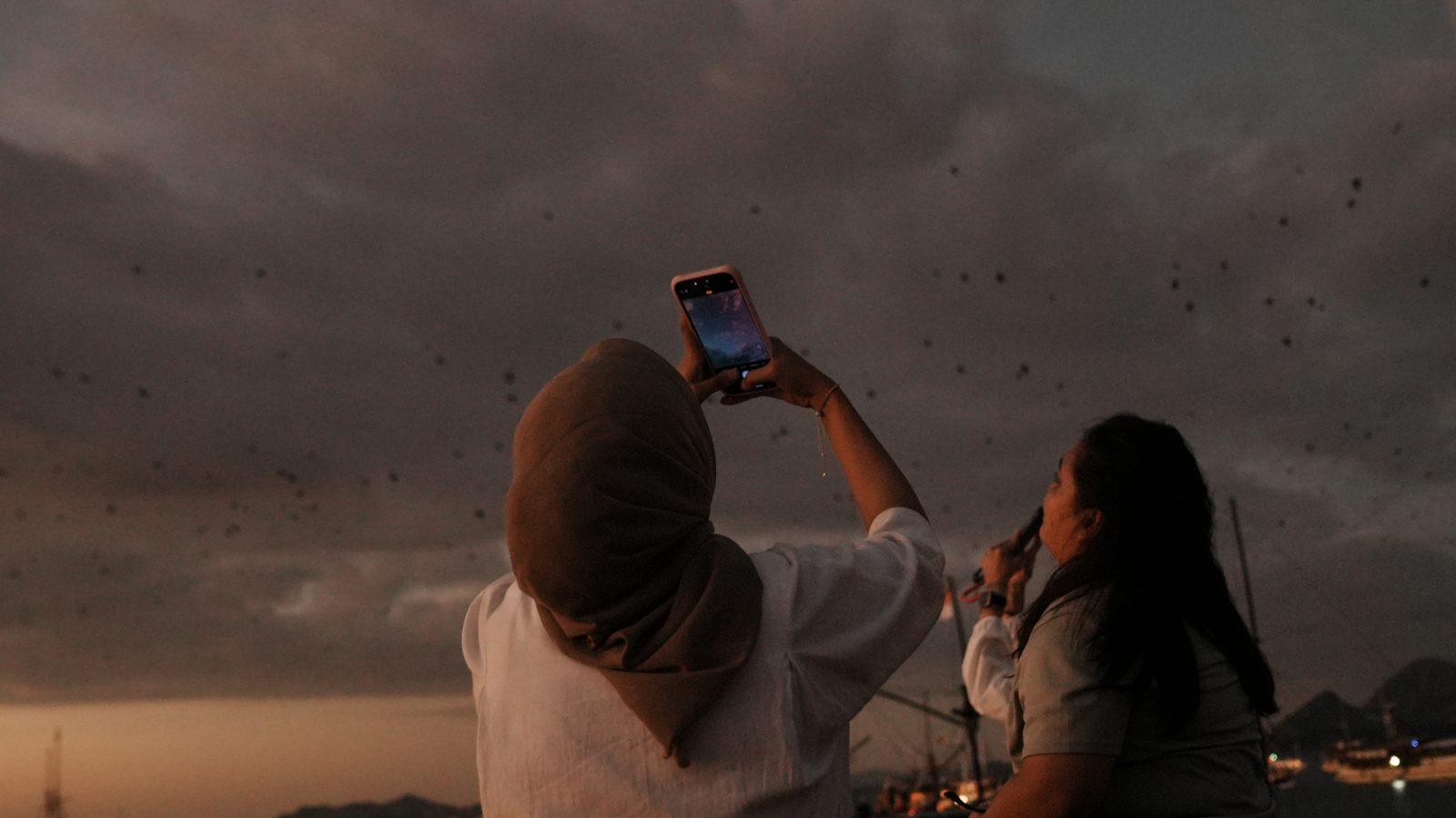 Kalong – Woman photographed as bats fly overhead (Taken on a real Komodo Explorer trip)