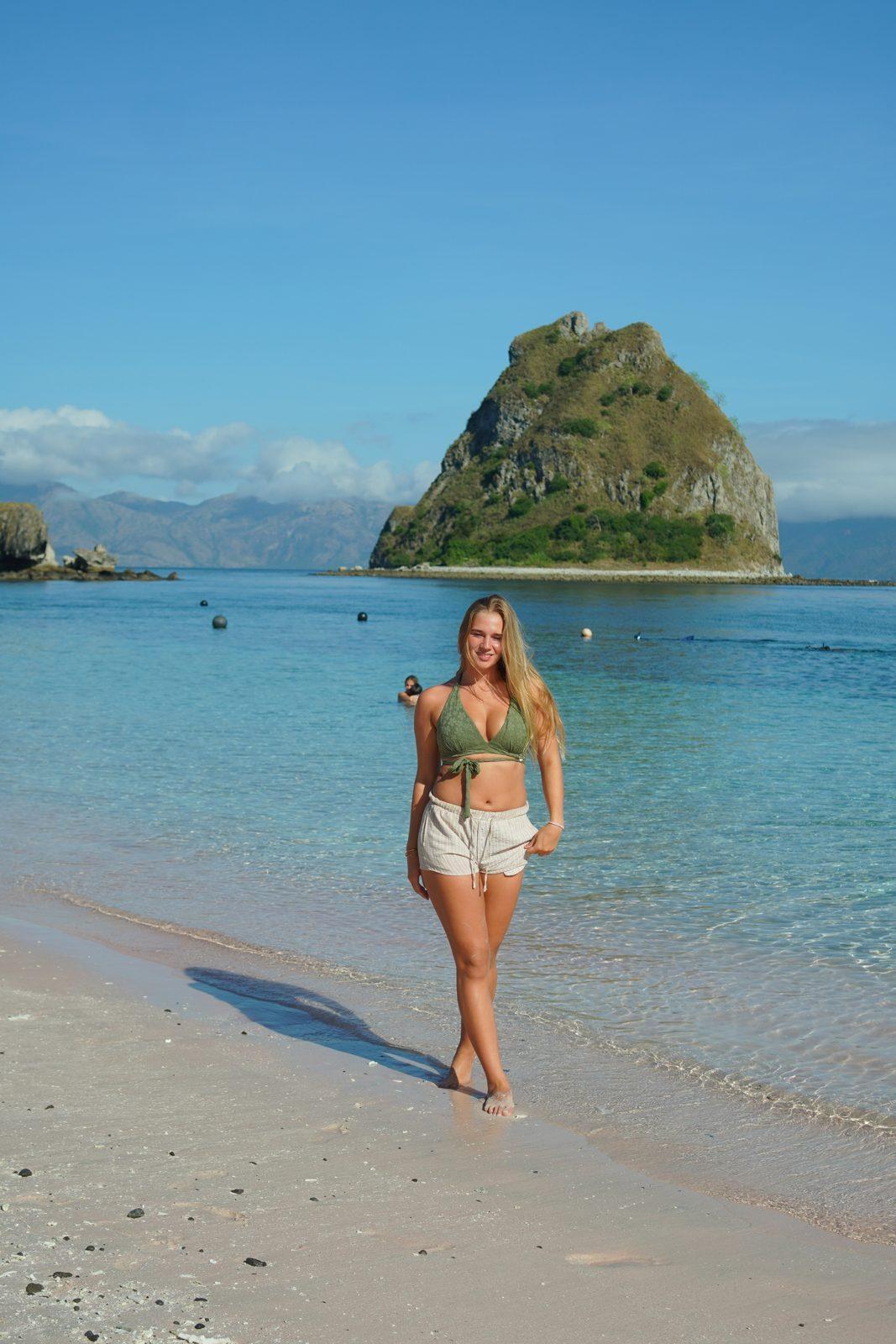 Kelor – woman standing on sand, islet behind (Taken on a real Komodo Explorer trip)