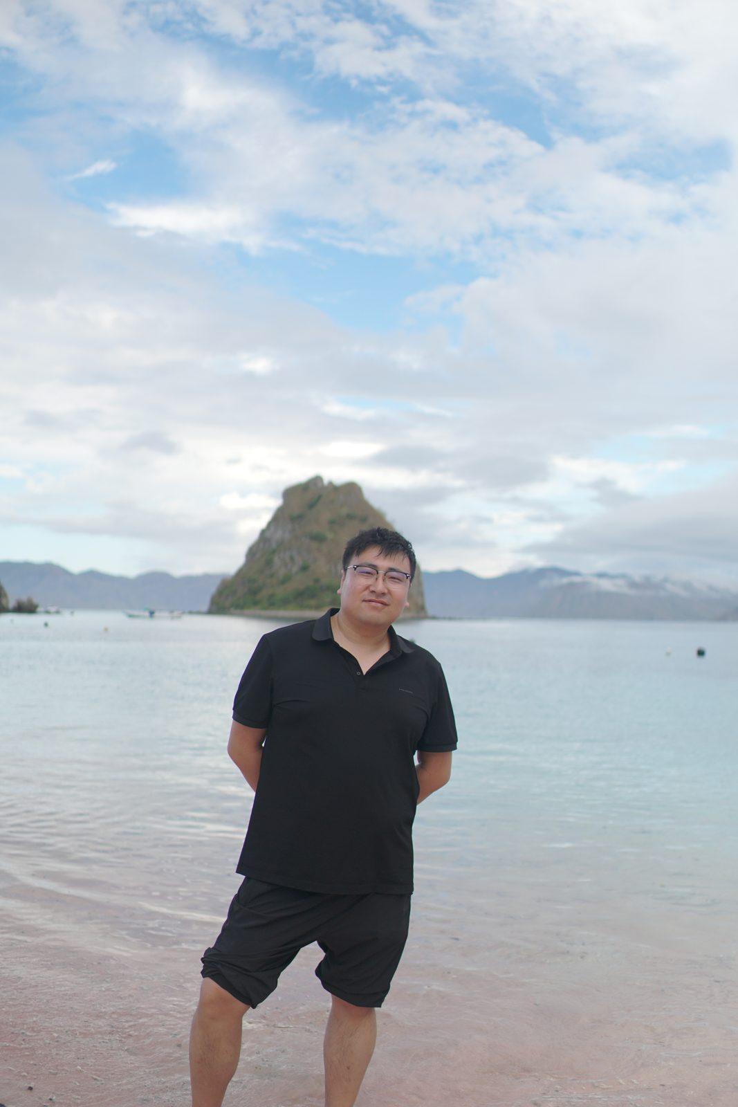 Kelor – man standing in shallows, islet behind (Taken on a real Komodo Explorer trip)