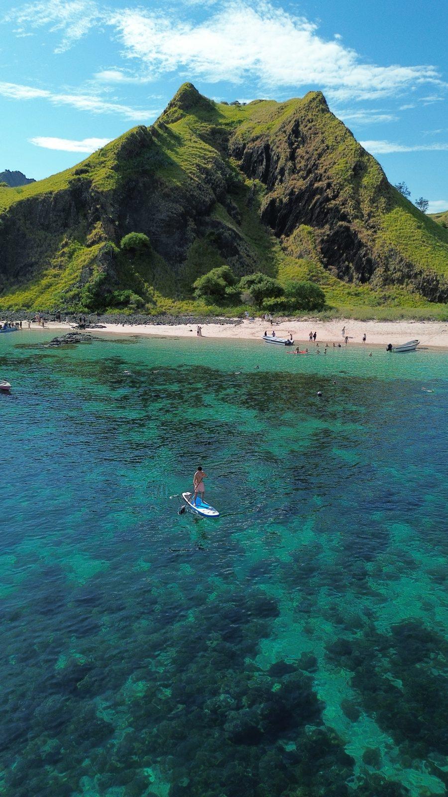 Kelor – paddleboarder off steep green hill island (Taken on a real Komodo Explorer trip)