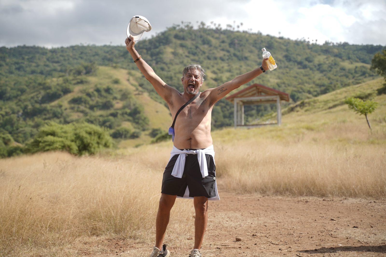 Komodo – Shirtless man cheering on savanna trail (Taken on a real Komodo Explorer trip)