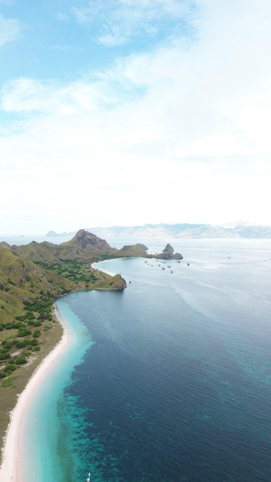 Padar – Aerial coastline, green headland, white beach (Taken on a real Komodo Explorer trip)