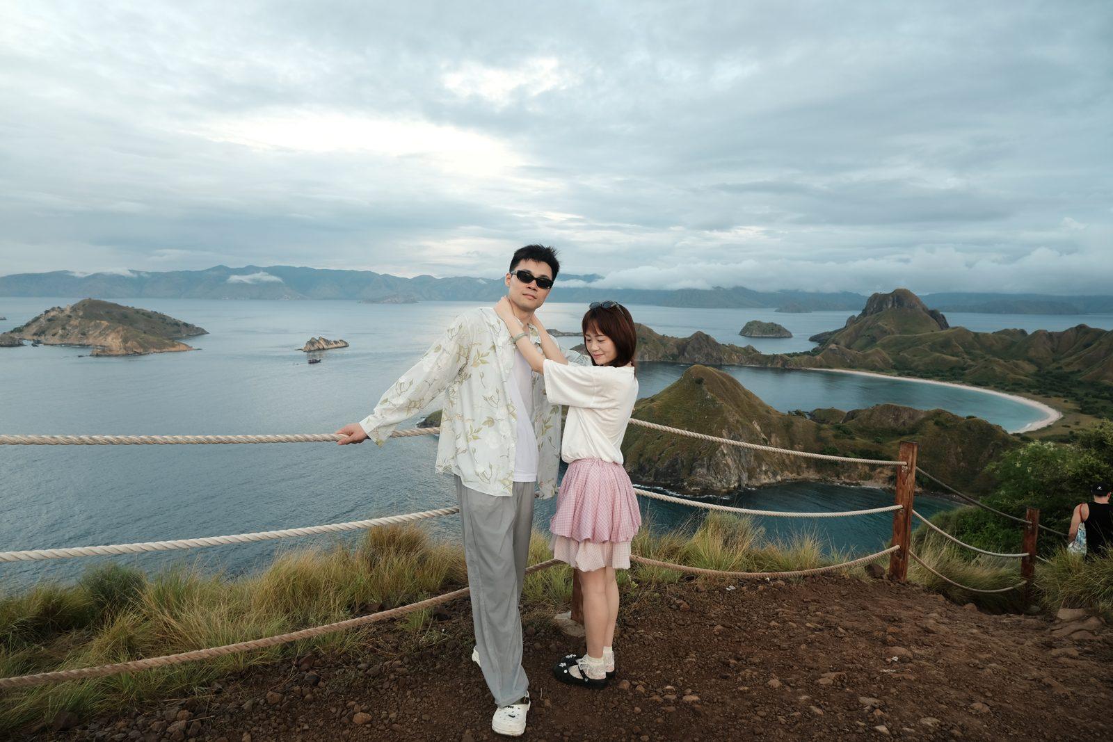 Padar – Couple posing at rail, wide Padar bays (Taken on a real Komodo Explorer trip)