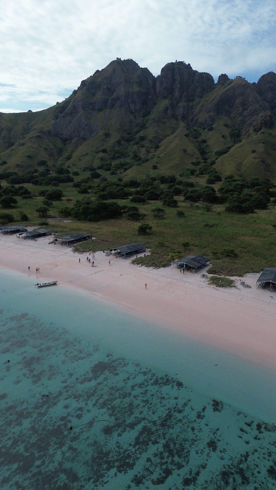 Pink Beach – Aerial pink beach below jagged green ridge (Taken on a real Komodo Explorer trip)