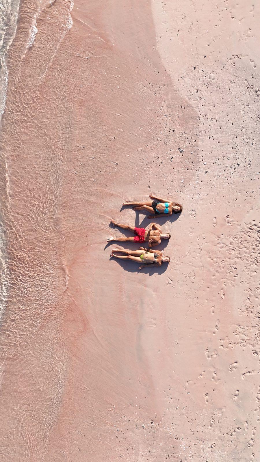 Pink Beach – two people lying on pink sand strip (Taken on a real Komodo Explorer trip)